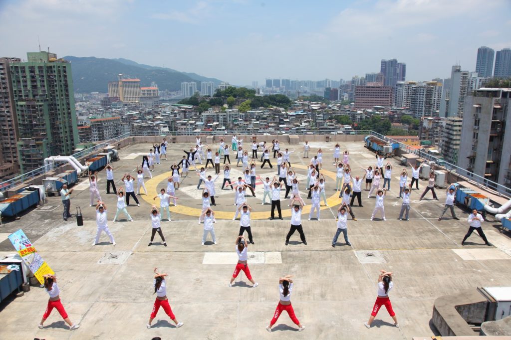 More than 80 people take part in group exercise on a high-rise rooftop during the TAFISA World Challenge Day in Macau, China.