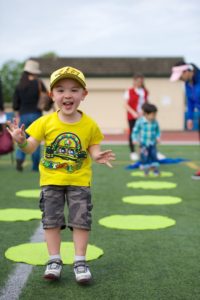 A boy smiles after taking part in a jumping challenge.